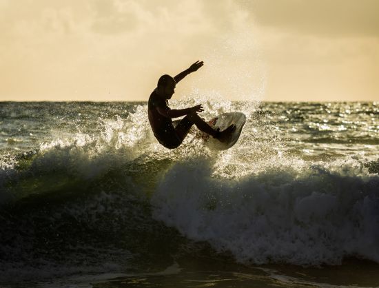 surfboard jump, showcasing the thrill of surfing in Arugam Bay, Sri Lanka's eco-friendly paradise.