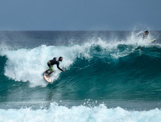 surfing on boards, riding a wave, capturing the essence of adventure in Negombo.