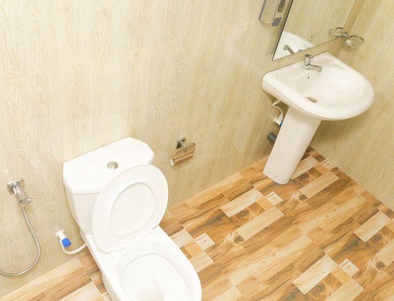 A clean and hygienic bathroom featuring a toilet, sink, and mirror at Mon Ami City Hotel, offering budget-friendly options.