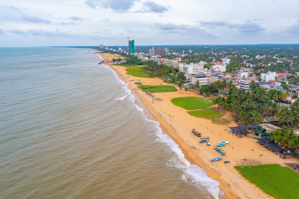 Aerial view showcasing the beach and cityscape of Negombo, Sri Lanka, highlighting Mon Ami City Hotel's location.