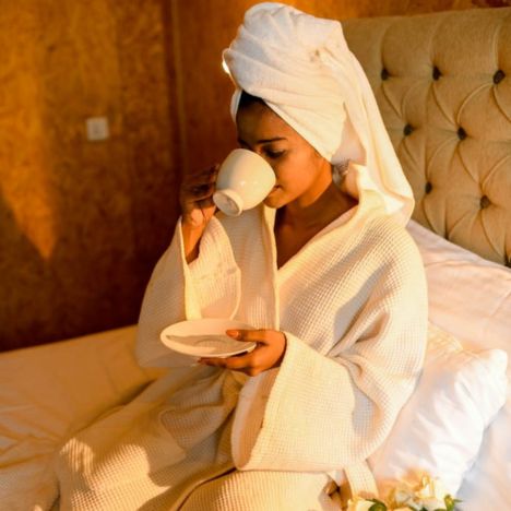 A model sips tea in the stylish Mon Ami City Hotel, highlighting the tranquil ambiance and refined decor.